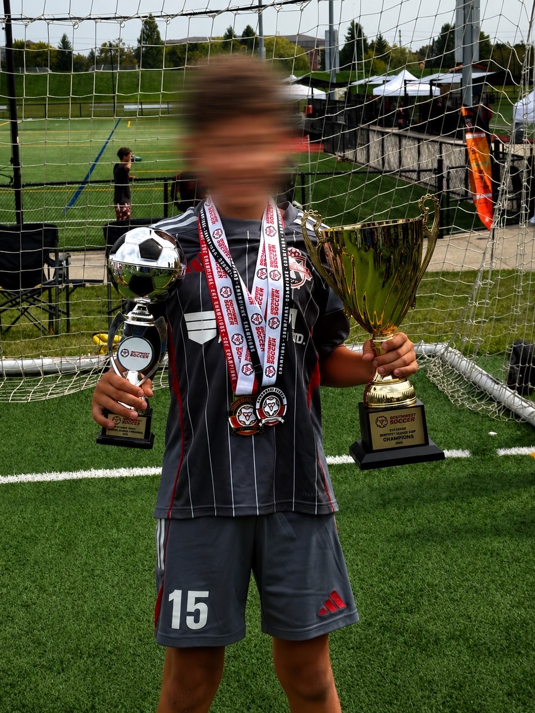 Zain Al Haj Ali holding the Southwest Soccer District League Cup and a player-of-the-tournament trophy.
